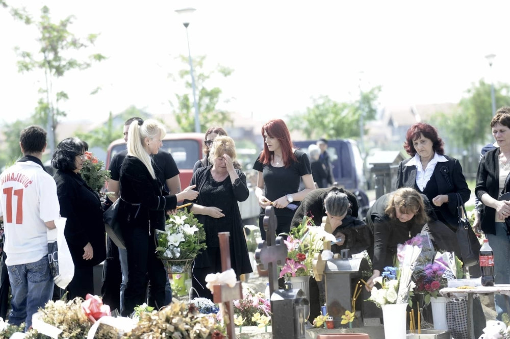 Jelenini majka i suprug zagrljeni pored groba