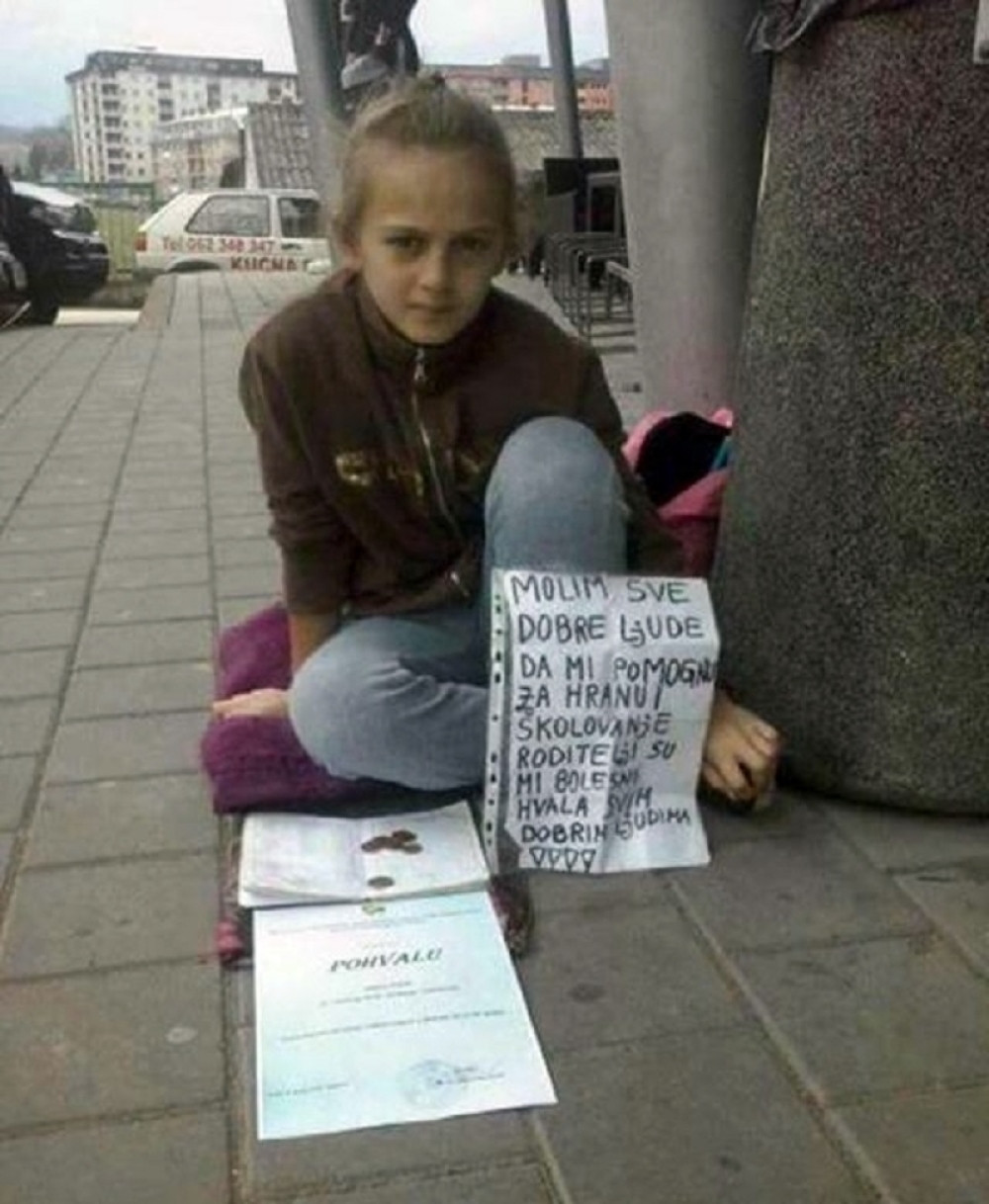 Devojčica prosi sa đačkom knjižicom u ruci