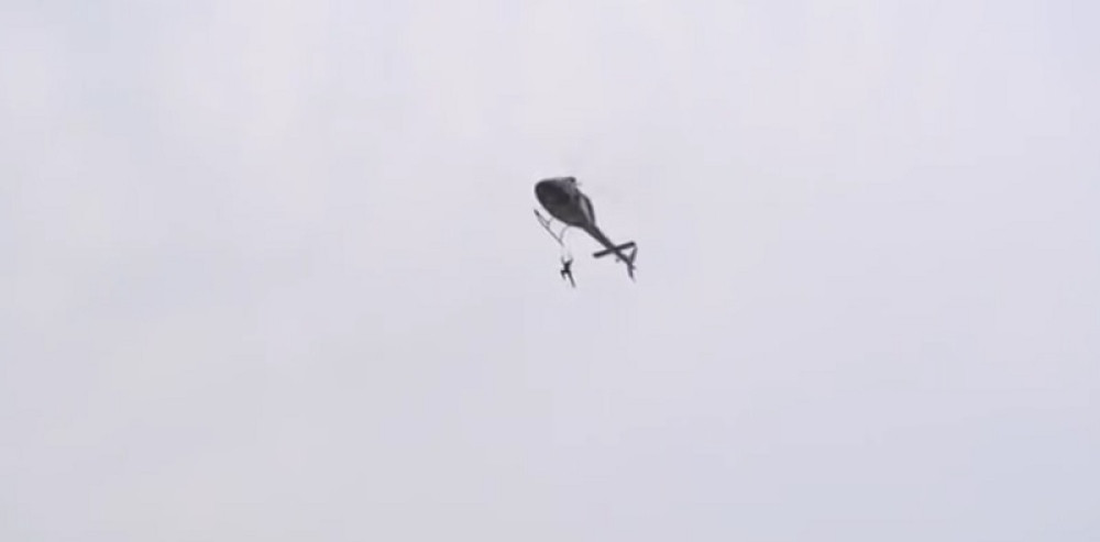 Visila iznad vodopada držeći se ZUBIMA za helikopter (VIDEO)