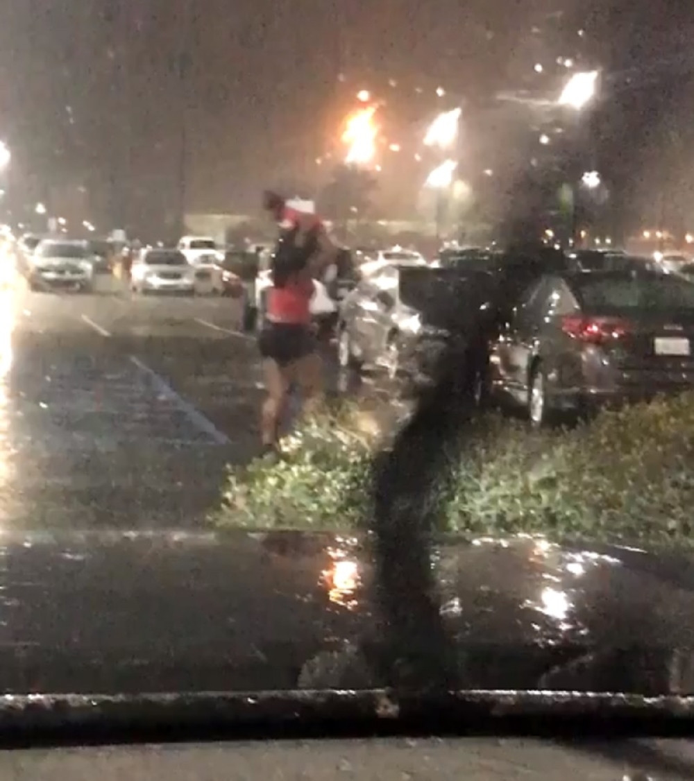 Uhvatila je kiša nasred parkinga, a evo šta je iskoristila kao kišobran! (VIDEO)