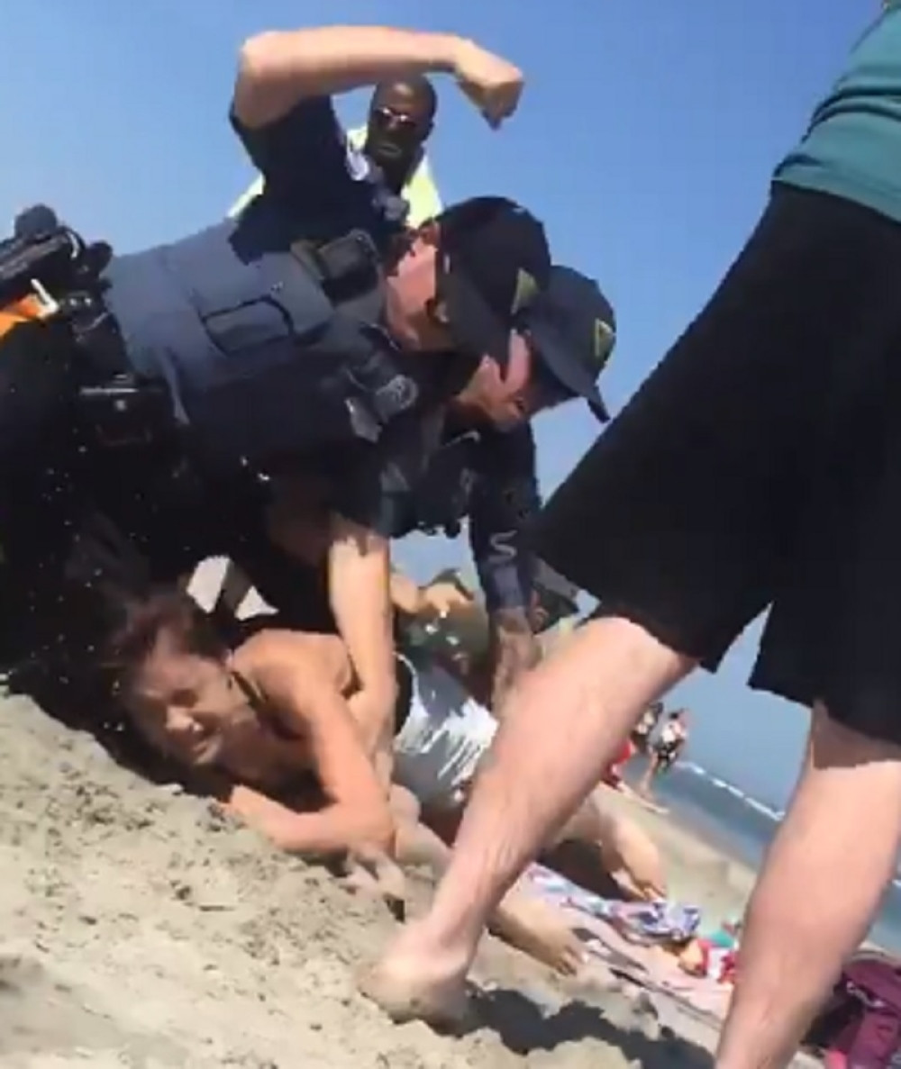 Policajac pesnicom udara devojku dok ona leži (VIDEO)