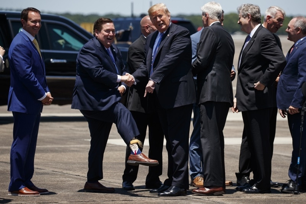 Pružio je ruku trampu, pa podigao nogavicu, ispala je GOMILA DLAGA, a na nogama je imao lik sa žutom kosom! (VIDEO)