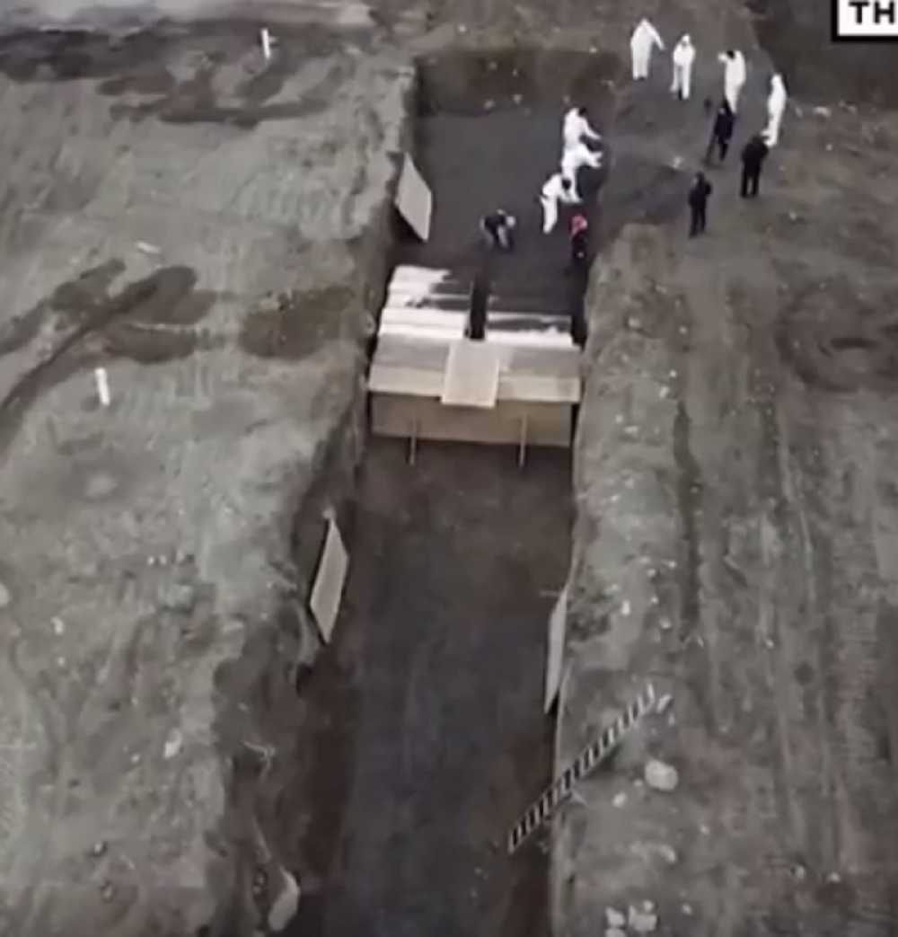 Sanduke sa mrtvima dovozi viljuškar, slažu ih jedne na druge i zatrpavaju u masovnoj grobnici (VIDEO)