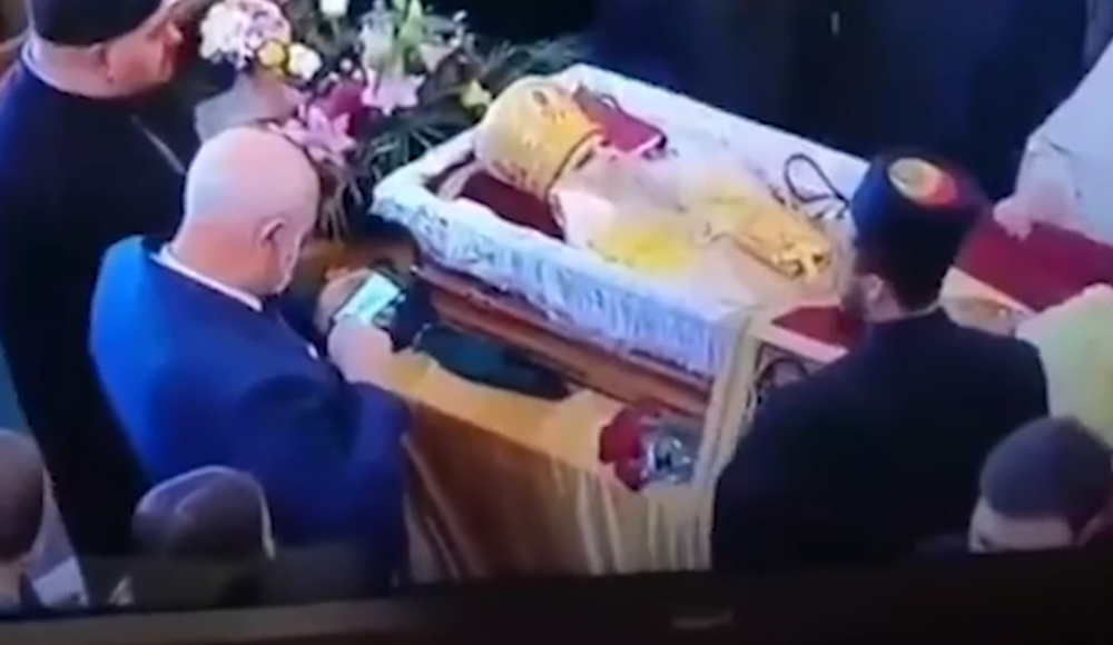 Čovek pozira i traži da ga slikaju dok ljubi preminulog mitropolita (VIDEO)